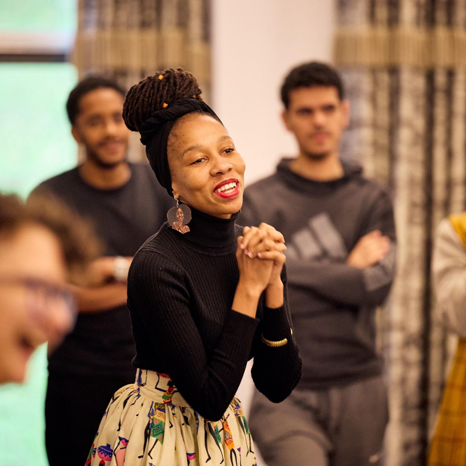 Mantate smiling with her hands clasped during a workshop